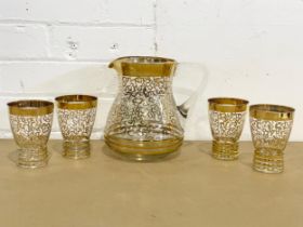 A 1960’s Mid Century gilt glass drinks set. A jug and 4 matching glasses. Jug 20x19cm. Glasses 11.