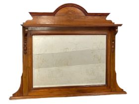 An Edwardian walnut over-mantle with a bevelled mirror. 120x91cm