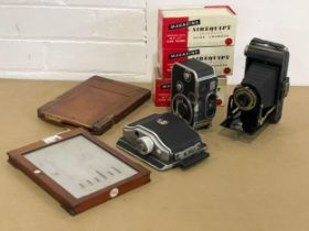A collection of cameras and accessories. A Paillard Bolex B8. A Linhof Rollex 6x9. A Kodak Folding