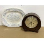 A vintage mantle clock with key and pendulum with a Victorian platter.