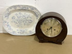 A vintage mantle clock with key and pendulum with a Victorian platter.