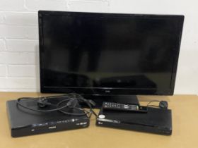 A Logik tv and remote with 2 DVD players. TV measures 75x51cm