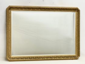 A large ornate gilt framed bevelled mirror. 100x71cm.
