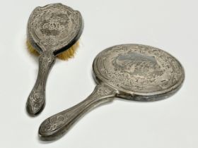 A sterling silver vanity brush and matching mirror.
