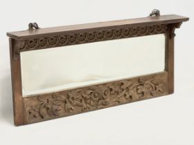 A late 19th century fine proportioned carved oak over-mantle mirror with tree leaf and rosette