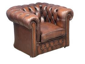 A deep button leather club armchair.