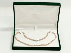 A vintage natural coloured pink pearl necklace with box.