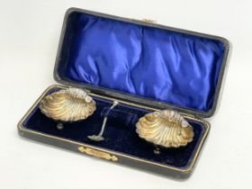 A pair of Victorian silver shell salts and spoon with case. Birmingham. 20.12 grams.