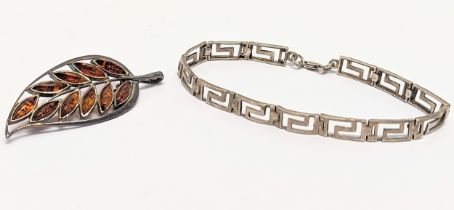 A silver bracelet with a silver brooch