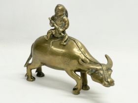 An early 20th century Chinese brass water buffalo with rider. 25x19.5cm