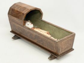 A late 19th century rocking baby’s cradle with doll. 60cm