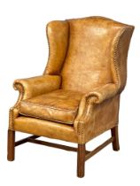 An excellent quality early 20th century Georgian style leather wingback armchair with metal studs.