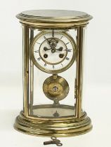 A large late 19th century French oval brass mantle clock with 4 bevelled glass panels and key.