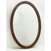 An early 20th century carved mahogany oval mirror. 58x83cm