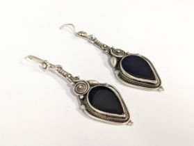 A pair of ornate silver earrings