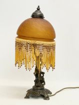 A vintage brass figurine table lamp with glass shade and droplet. 47.5cm