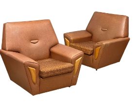 A pair of Mid Century faux leather armchairs.