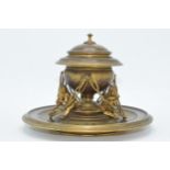 Unusual gilt bronze inkwell set on a circular base with figural characters with tools surrounding