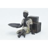 Cold painted bronze figure of a seated gentleman holding a mussels dish, 18cm wide.