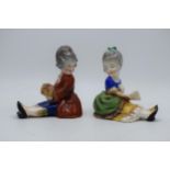 A pair of early Hummel / Goebel bookends of seated girls, one holding a fan, the other flowers,