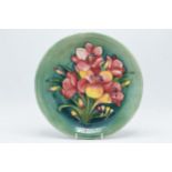 Moorcroft charger / plate in a pink and yellow floral design, 26cm diameter. In good condition