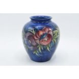 Moorcroft Clematis / floral design bulbous vase on blue background, 15cm tall. In good condition