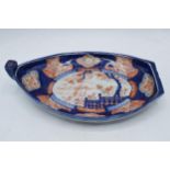 19th century Imari pottery dish in the form of a shallow boat with traditional scenes, 32cm long.