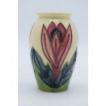 Moorcroft vase on cream background with floral design, 10.5cm tall. In good condition with no