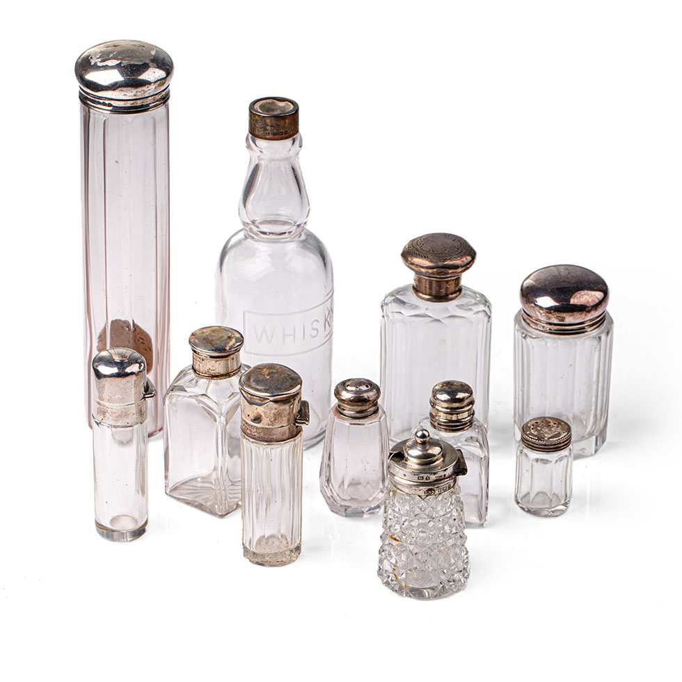 A collection of hallmarked silver topped glass containers to include cruets, perfume and others (