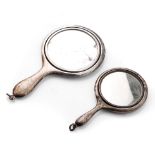 A pair of miniature silver hand mirrors, largest 11cm long, hallmarks rubbed (2).