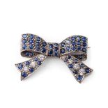 14ct white gold (tests as) brooch in the form of a bow, set with white and blue sapphires, 6.0