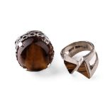 Silver chunky ornate ring set with large tiger's eye together with a modernist similar example (2).