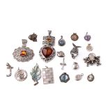 An interesting collection of silver pendants and charms to include a fish, small hearts, fob-style