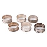 A collection of hallmarked silver napkin rings with varying designs, 59.6 grams (6).