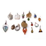 An interesting collection of silver pendants with various gemstones and similar materials of varying