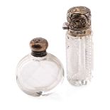 A pair of silver topped scent bottles, one with oval shape, the other bright-cut glass, both early