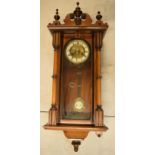 Edwardian wooden Vienna clock with arched-style door and turned decoration, 90cm tall, with pendulum
