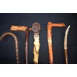 A collection of vintage walking sticks, one with handle in the form of a head, together with 4