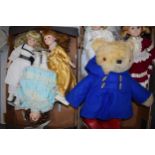 A collection of child's bisque faced dolls in various dresses and styles together with Paddington