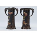 A pair of Bretby art pottery vases, both with two handles, decorated with birds amongst foliage,