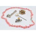 A collection of jewellery to include a silver bracelet, a silver thistle brooch, a coral necklace