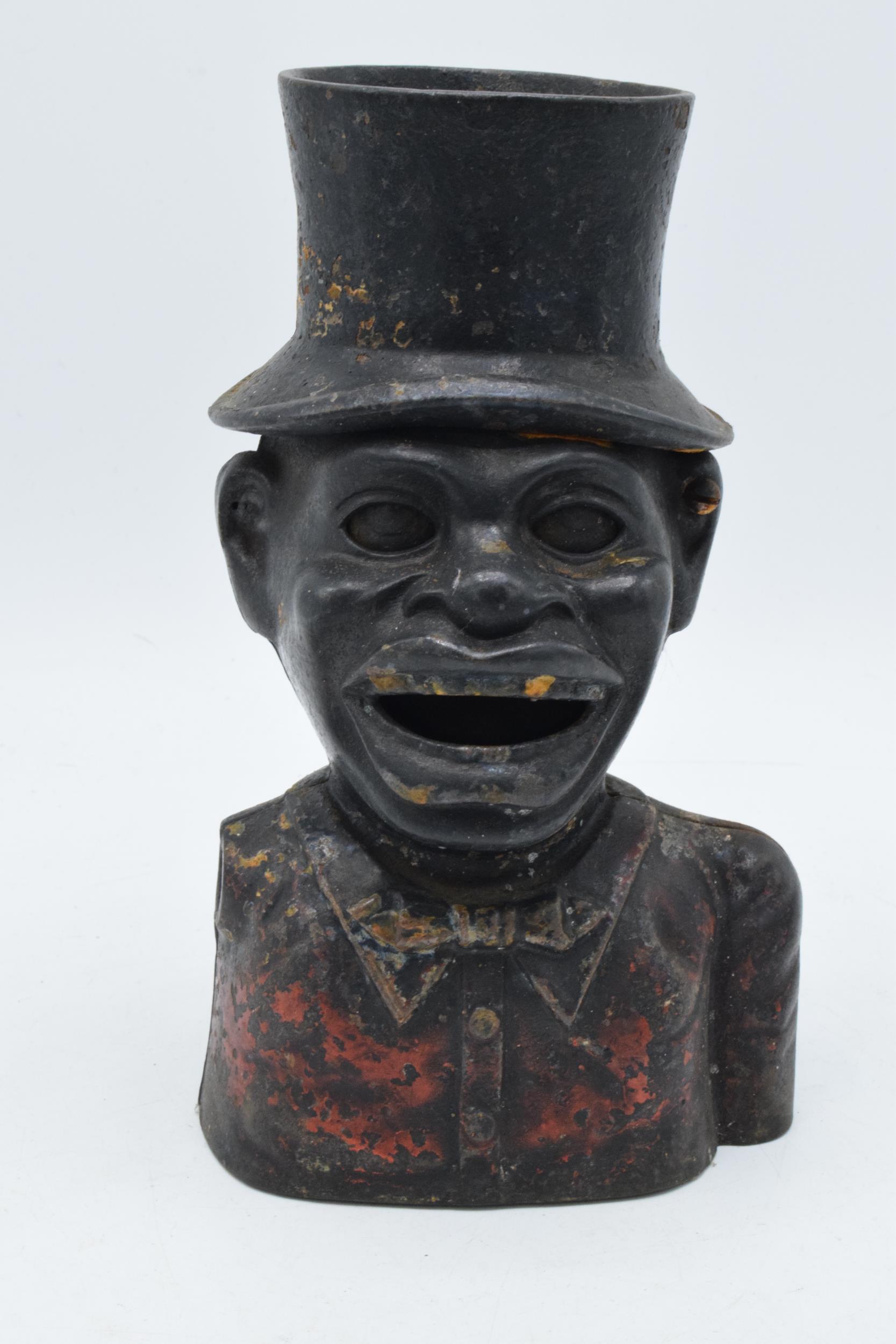 Cast metal jolly man money box with marks to ear, missing arm, 21cm tall.