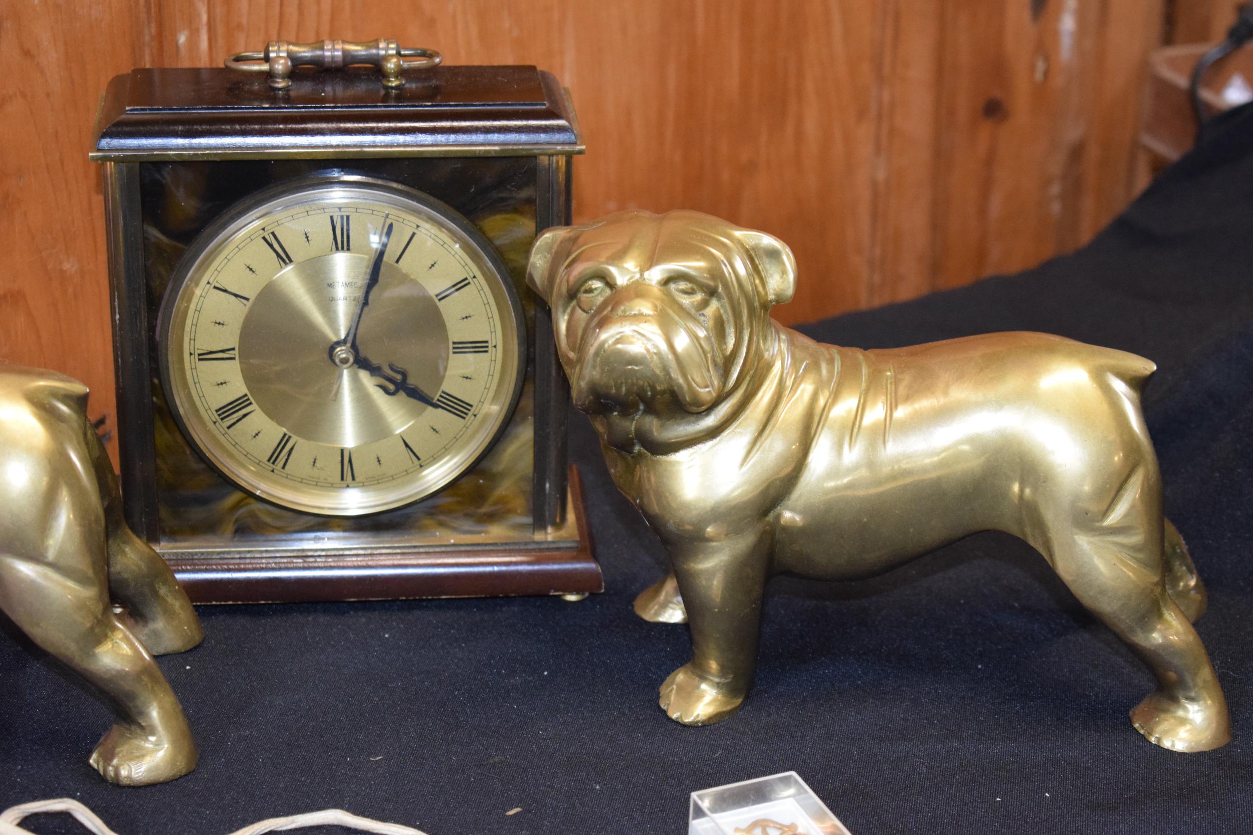 A pair of cast brass bulldog figures together with a mantle clock and 2 enamelled badges. - Image 2 of 3