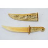 Oriental vintage bone cased dagger with engraved traditional scenes to blade and case, 26cm wide.