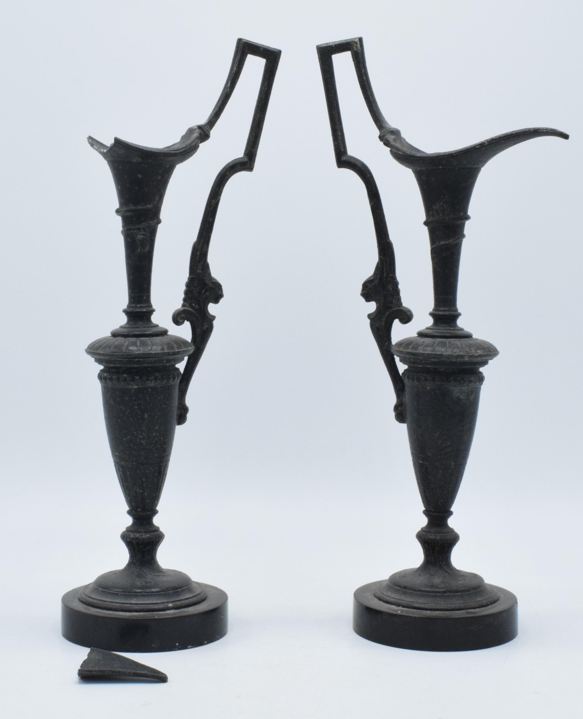 A pair of attractive spelter vases with figural handles on slate bases, damage to spout (2), 31cm