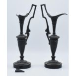 A pair of attractive spelter vases with figural handles on slate bases, damage to spout (2), 31cm