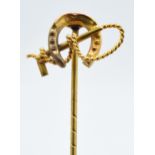 9ct gold stick pin in the form of a riding crop and horseshoe, 1.3 grams, 5cm long.