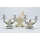 A pair of 20th century Dresden style continental candlesticks with cherubs amongst foliage