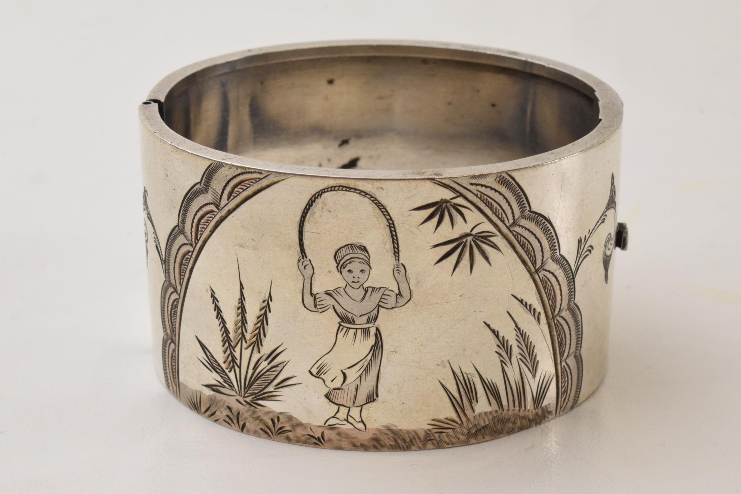 Silver engraved wide bangle with a girl skipping amongst foliage, 47.3 grams. No hallmarks but tests