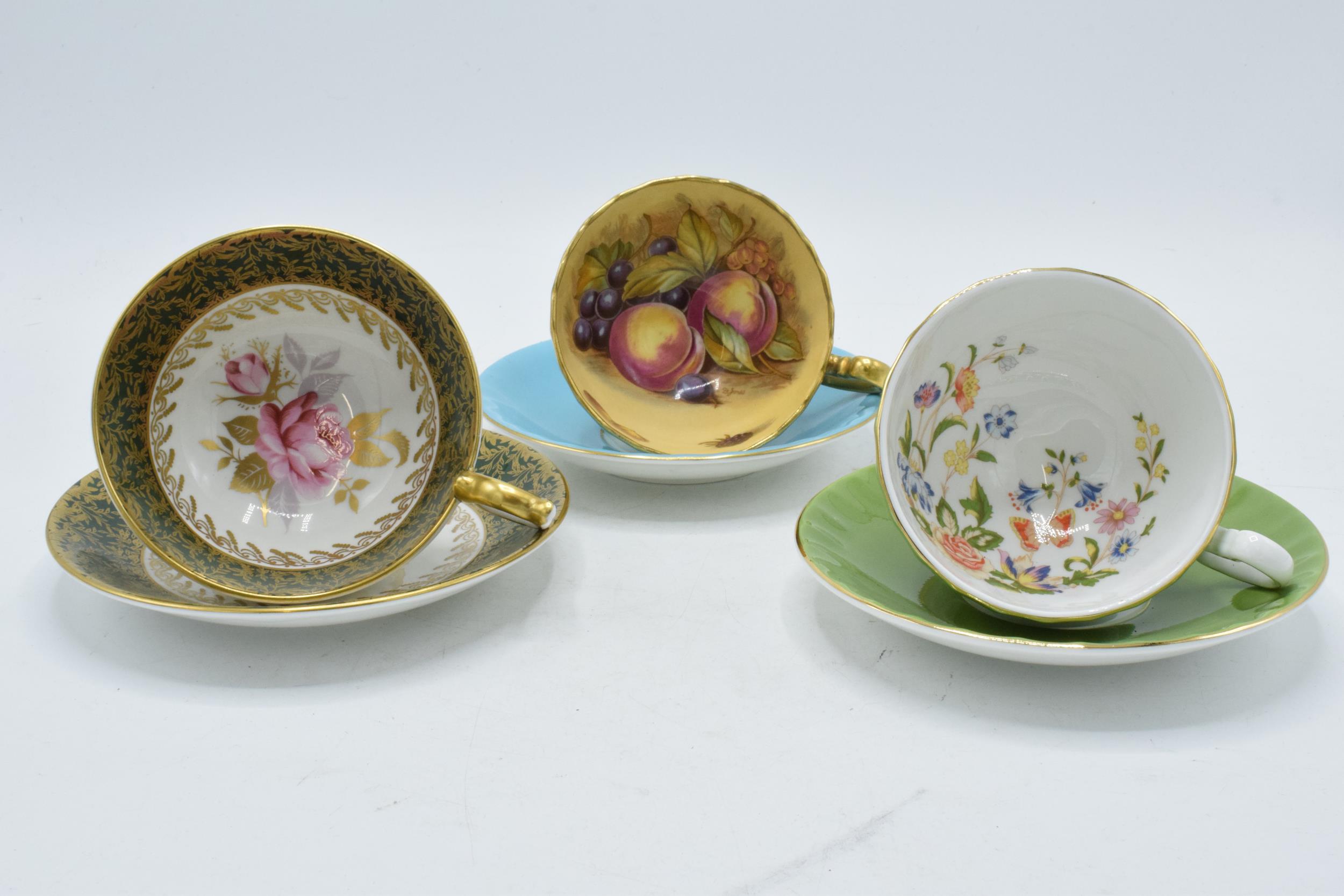 Aynsley cups and saucers to include an Orchard Gold on blue, signed D James, another with a pink